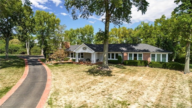 ranch-style home featuring a porch and a front yard