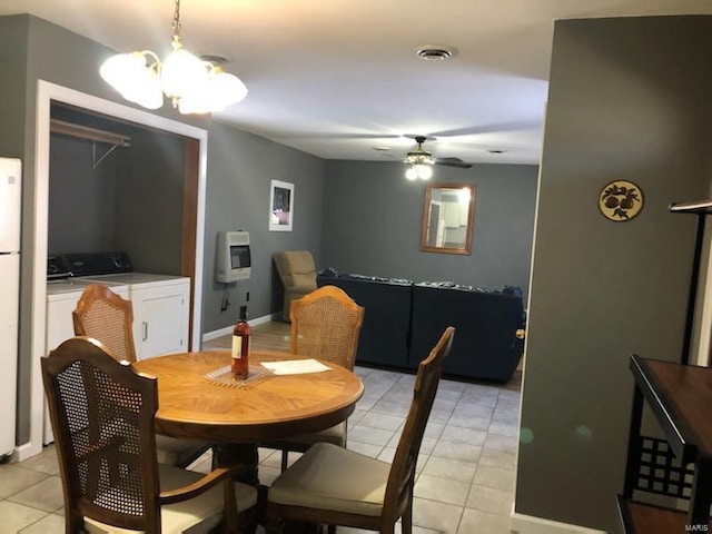 tiled dining area featuring washer and clothes dryer and ceiling fan with notable chandelier