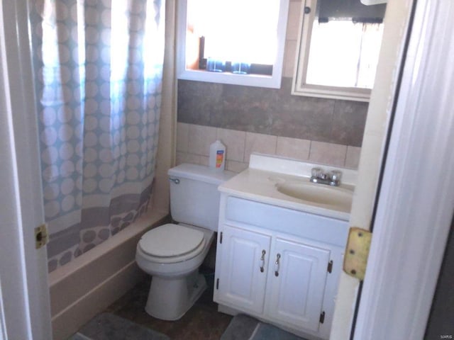 full bathroom featuring shower / tub combo, toilet, vanity, and tile walls