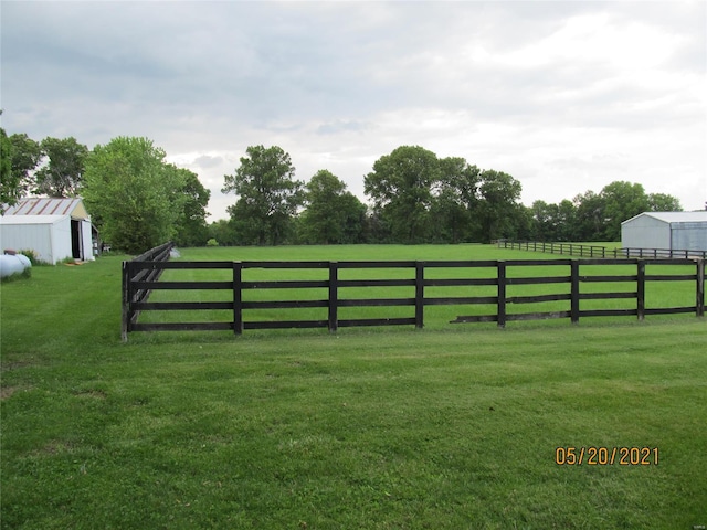 view of yard with a rural view and an outdoor structure