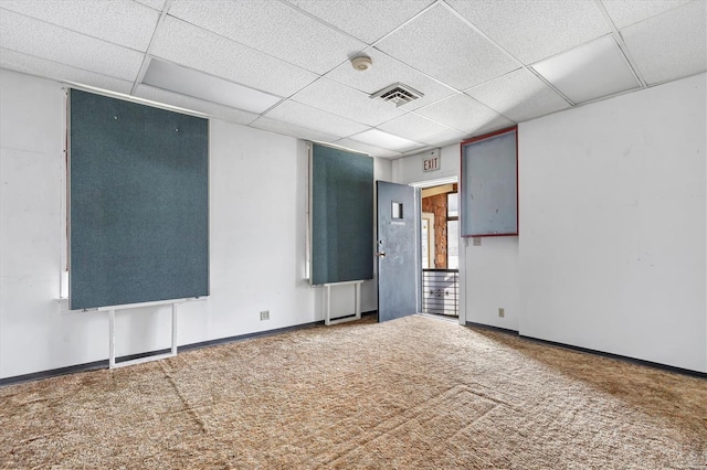 carpeted empty room with a paneled ceiling