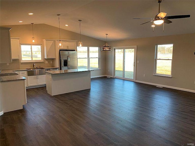 kitchen featuring dark hardwood / wood-style floors, a kitchen island, stainless steel refrigerator with ice dispenser, and pendant lighting