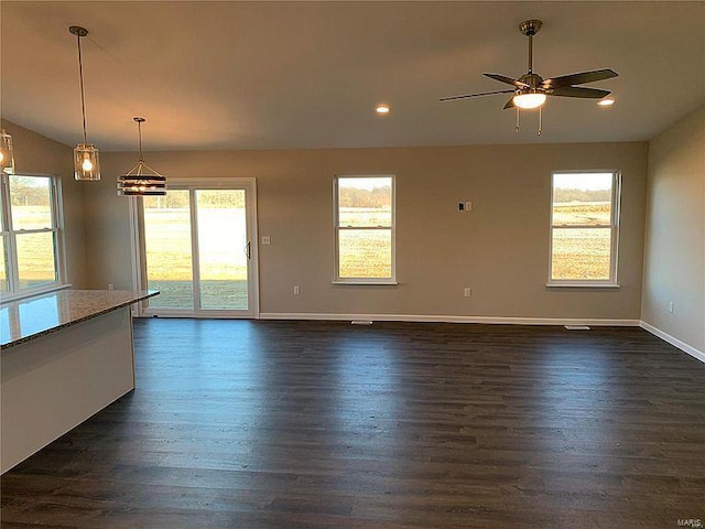 unfurnished living room featuring dark hardwood / wood-style flooring and ceiling fan