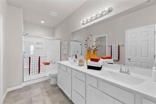 bathroom with tile flooring, a shower with door, toilet, and double vanity