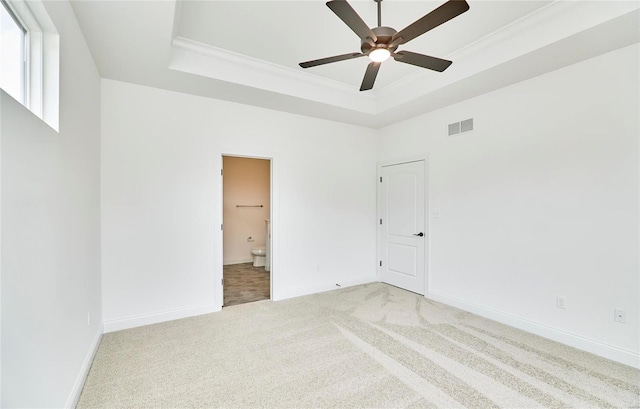 carpeted spare room featuring a high ceiling, a raised ceiling, ornamental molding, and ceiling fan