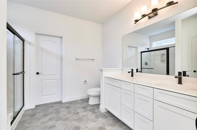 bathroom with dual sinks, oversized vanity, tile flooring, toilet, and a shower with shower door