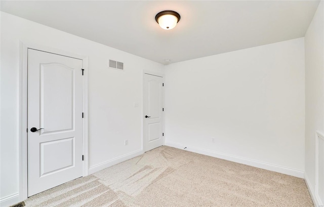 unfurnished bedroom featuring a closet and light colored carpet