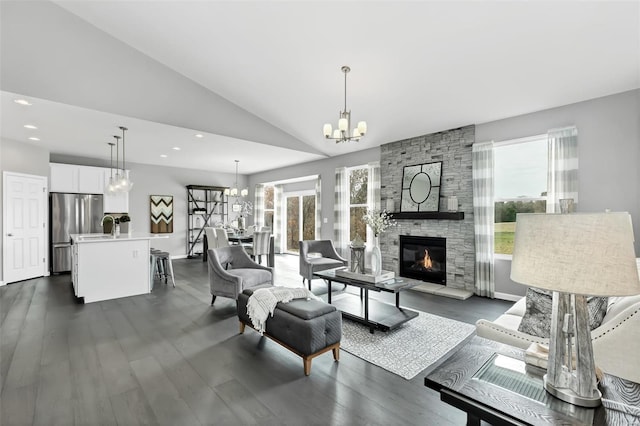 living room featuring dark wood-type flooring, a notable chandelier, high vaulted ceiling, and a fireplace