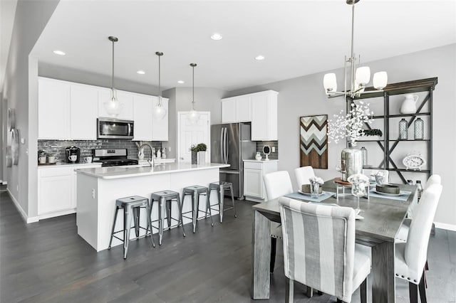 dining space with sink, a chandelier, and dark hardwood / wood-style flooring