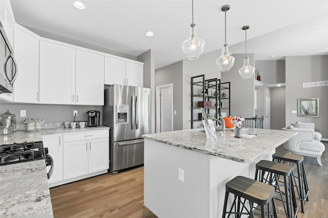 kitchen featuring light hardwood / wood-style flooring, stainless steel appliances, light stone counters, and white cabinetry