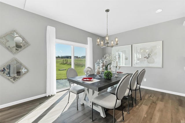 dining room with dark hardwood / wood-style floors and a chandelier