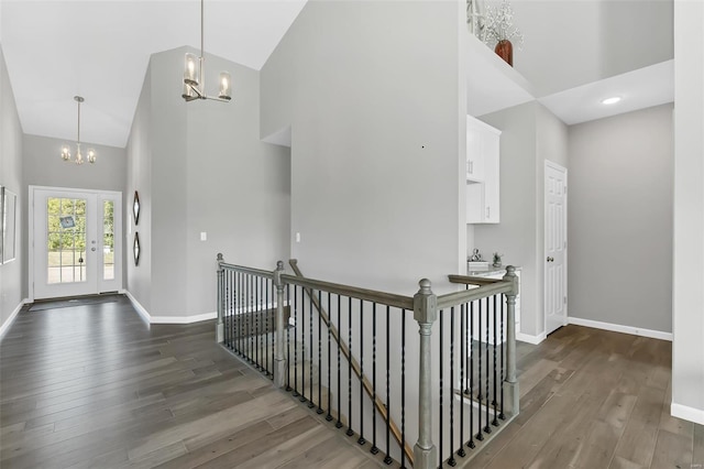 hall featuring high vaulted ceiling, an inviting chandelier, and dark wood-type flooring