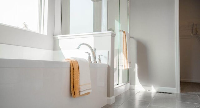 interior details featuring light tile flooring and plus walk in shower