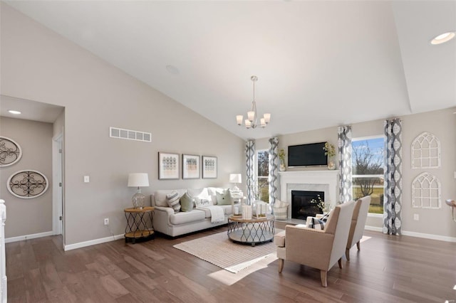 living room featuring high vaulted ceiling, dark hardwood / wood-style floors, and a chandelier