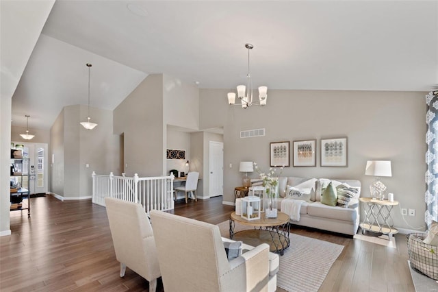 living room featuring high vaulted ceiling, a chandelier, and dark hardwood / wood-style flooring