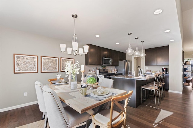 dining room with sink, a chandelier, and dark hardwood / wood-style flooring