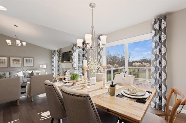 dining space featuring dark hardwood / wood-style flooring, a notable chandelier, and lofted ceiling