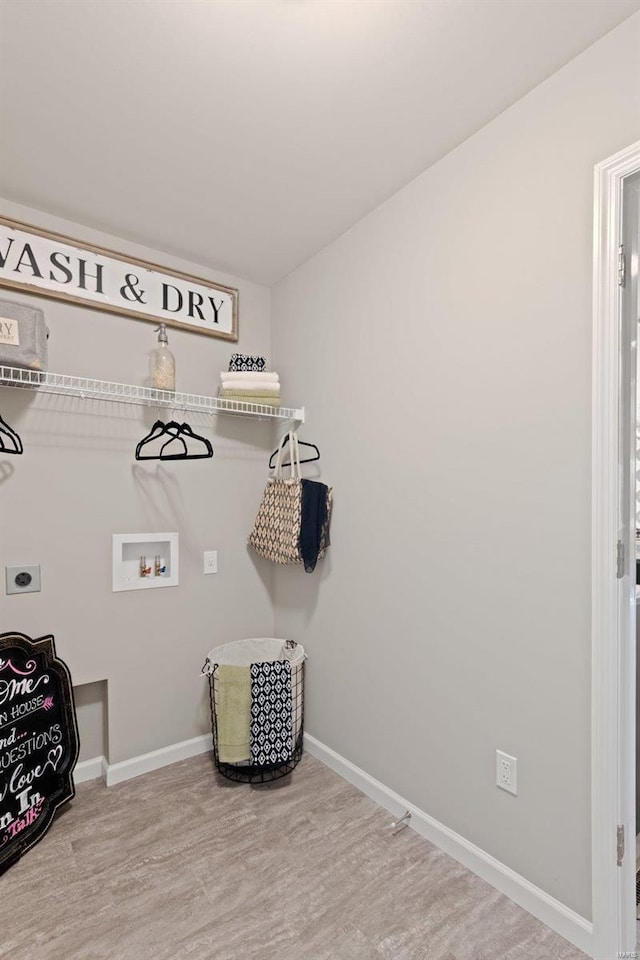 clothes washing area with light hardwood / wood-style flooring, electric dryer hookup, and washer hookup