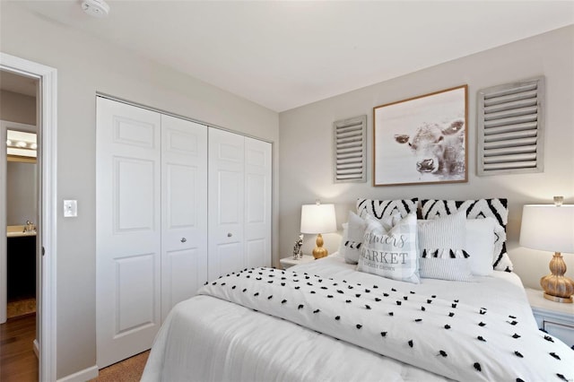 bedroom with sink, light wood-type flooring, and a closet