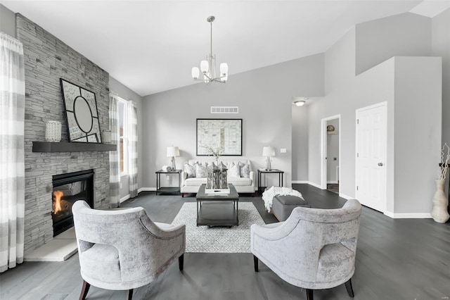 living room featuring lofted ceiling, an inviting chandelier, dark hardwood / wood-style floors, and a fireplace