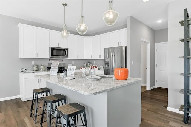 kitchen with appliances with stainless steel finishes, dark wood-type flooring, and white cabinets