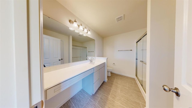 bathroom with toilet, vanity, and tile patterned flooring