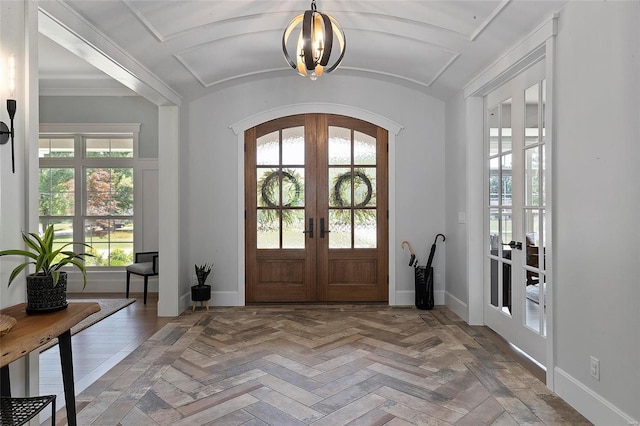 entryway featuring a notable chandelier, french doors, crown molding, and plenty of natural light