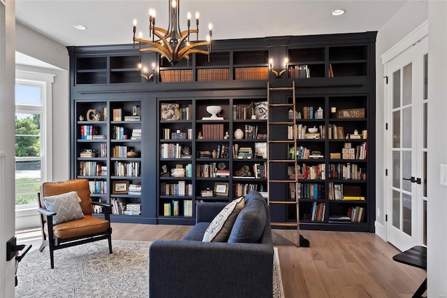 living area featuring light wood-type flooring and a chandelier