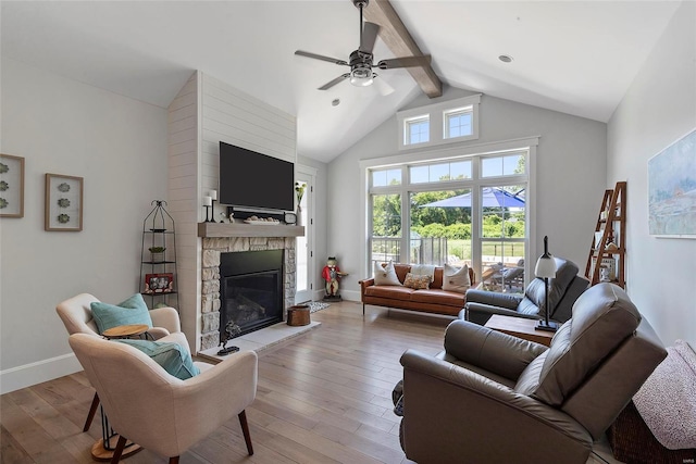 living room with ceiling fan, a fireplace, beamed ceiling, high vaulted ceiling, and light hardwood / wood-style flooring