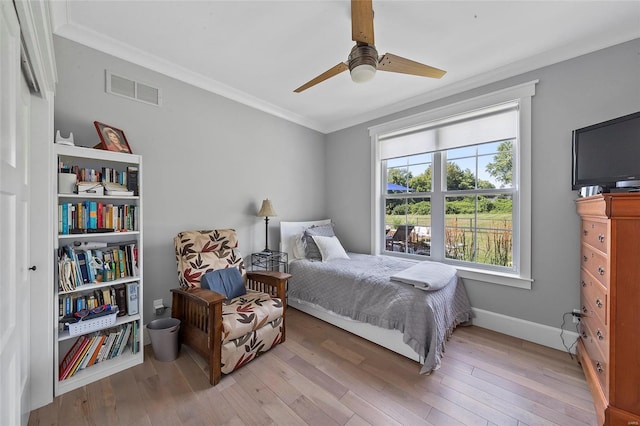 bedroom featuring ornamental molding, ceiling fan, and light wood-type flooring