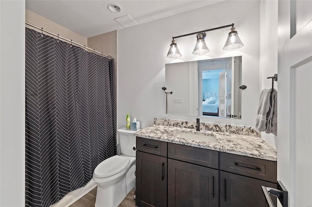 bathroom with hardwood / wood-style flooring, toilet, and vanity