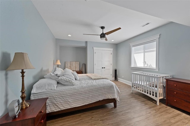 bedroom with a closet, hardwood / wood-style floors, and ceiling fan