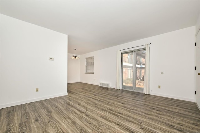 unfurnished living room featuring wood-type flooring and an inviting chandelier