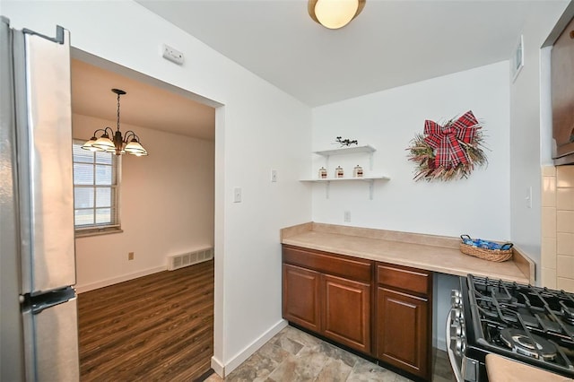 kitchen with an inviting chandelier, light hardwood / wood-style floors, stainless steel refrigerator, stove, and decorative light fixtures