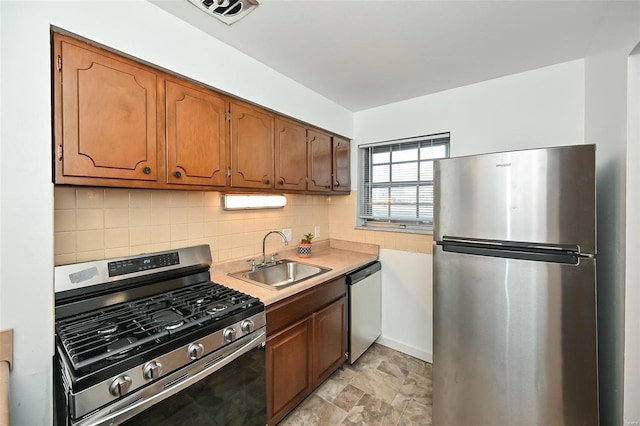 kitchen featuring sink, stainless steel appliances, light tile patterned flooring, and decorative backsplash