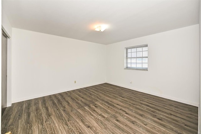 unfurnished room with dark hardwood / wood-style flooring