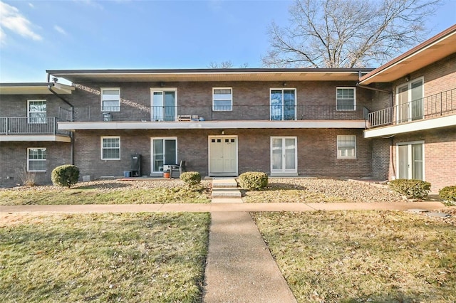 view of front of property featuring a balcony and a front yard