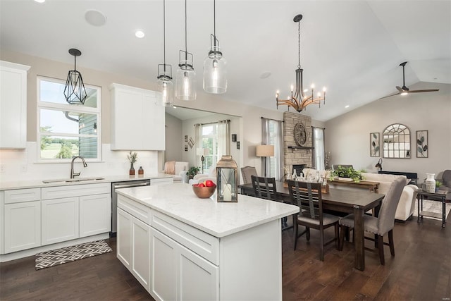 kitchen with ceiling fan with notable chandelier, white cabinetry, hanging light fixtures, dark hardwood / wood-style floors, and sink