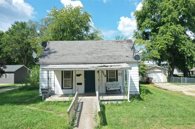 bungalow-style house with a porch, a front lawn, and a garage