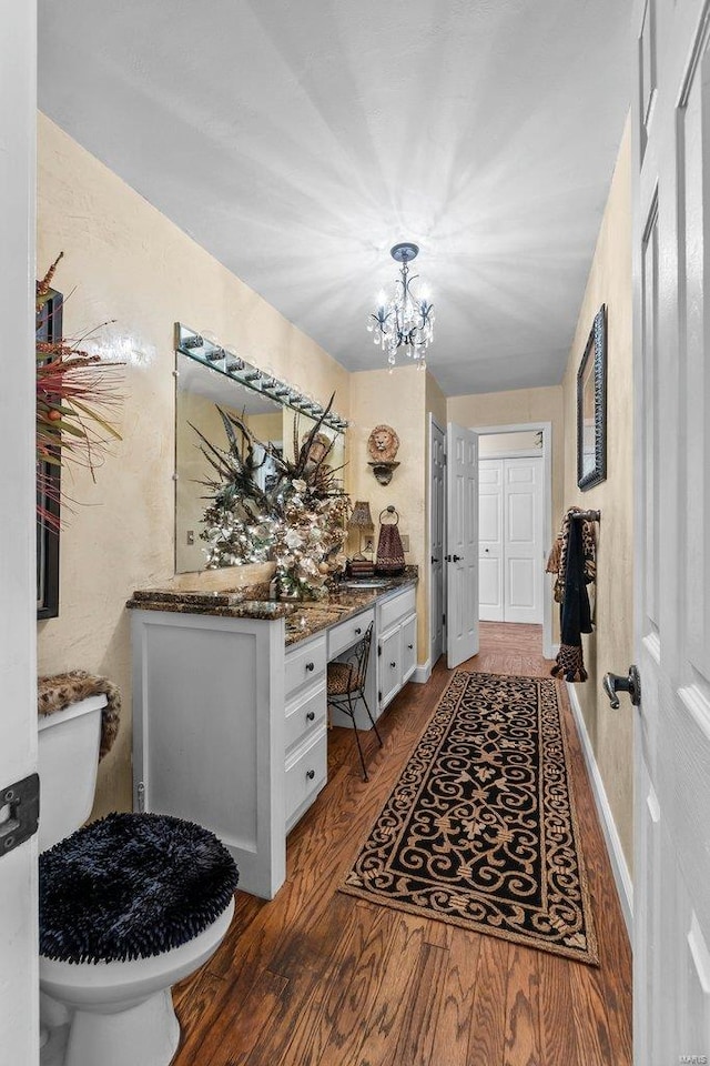 bathroom with a chandelier, toilet, hardwood / wood-style floors, and vanity