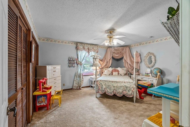 bedroom with ceiling fan, a closet, light colored carpet, and a textured ceiling