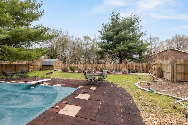 view of pool featuring a storage unit, a yard, a diving board, and a patio