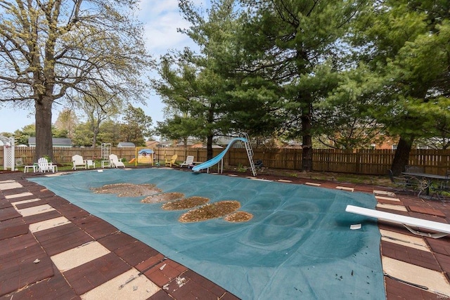 view of pool with a water slide, a diving board, and a patio