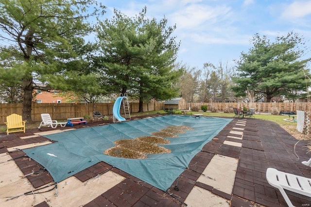 view of swimming pool featuring a water slide and a patio area