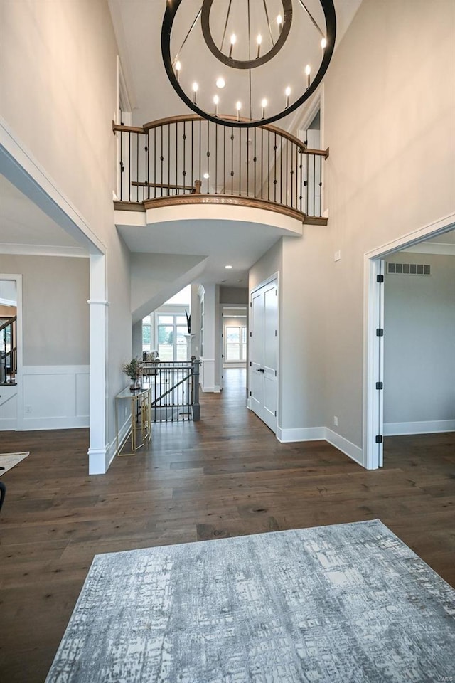 interior space with a notable chandelier, crown molding, and wood-type flooring