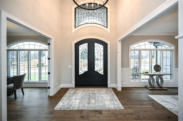 entrance foyer with french doors, dark hardwood / wood-style flooring, and a chandelier