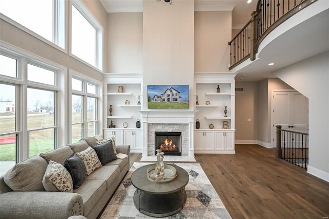 living room with a high ceiling, a fireplace, and a healthy amount of sunlight