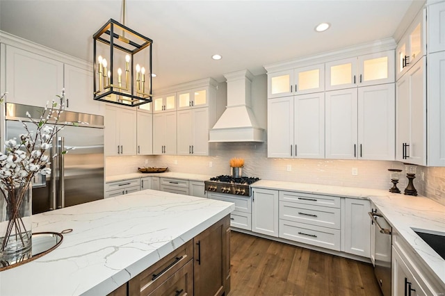 kitchen with white cabinets, pendant lighting, premium range hood, and appliances with stainless steel finishes