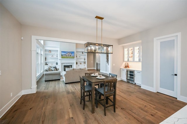 dining area featuring an inviting chandelier, hardwood / wood-style floors, and wine cooler