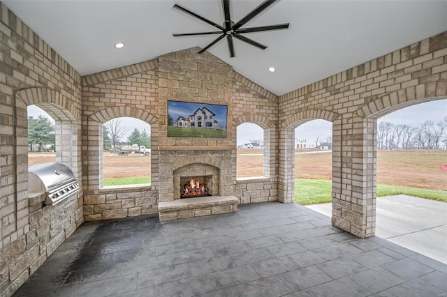 view of patio / terrace with an outdoor kitchen, grilling area, ceiling fan, and an outdoor stone fireplace